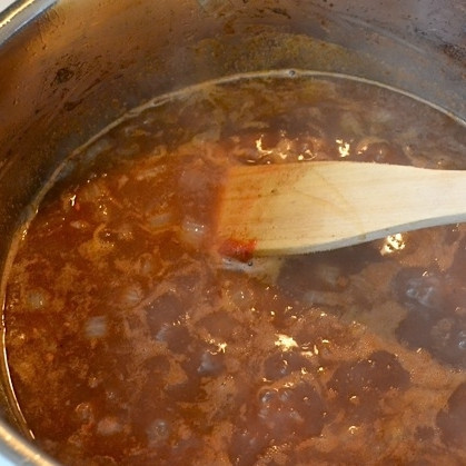 1. Этап. Мясо по-мароккански: Когда вино выпарится практически полностью, добавляем в сковороду томатную пасту, мед, соль, острый перец и приблизительно 3 стакана воды. Доводим смесь до кипения, затем накрываем крышкой, ставим на медленный огонь и тушим 1 час.