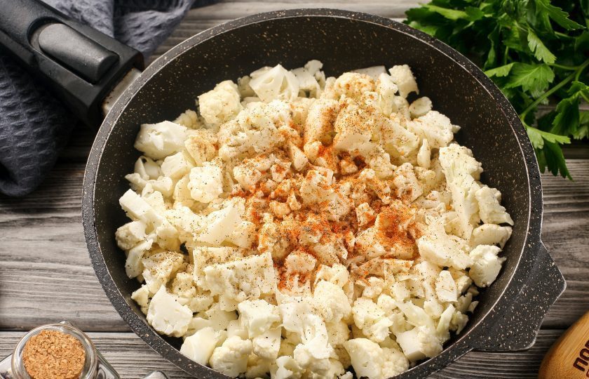 1. Этап. Запеканка из цветной капусты на сковороде: Растопите на сковороде кусочек сливочного масла, добавьте нарезанные соцветия капусты, соль и специи по вкусу.