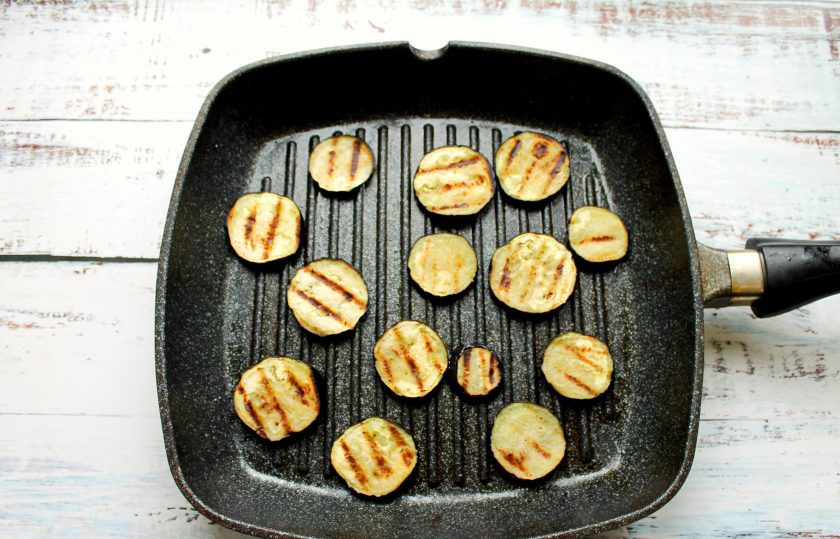 1. Этап. Салат с халуми и баклажанами: Баклажан порежьте на кружочки толщиной 1 сантиметр. Выложите в миску, залейте холодной водой, посолите и оставьте на 15 минут. Затем слейте воду, сполосните и обсушите. Разогрейте сковороду гриль, смажьте немного растительным маслом. В баклажаны добавьте растительное масло, посолите и перемешайте. Выложите кружочки овоща в сковороду-гриль и обжарьте с двух сторон, переложите на тарелку.