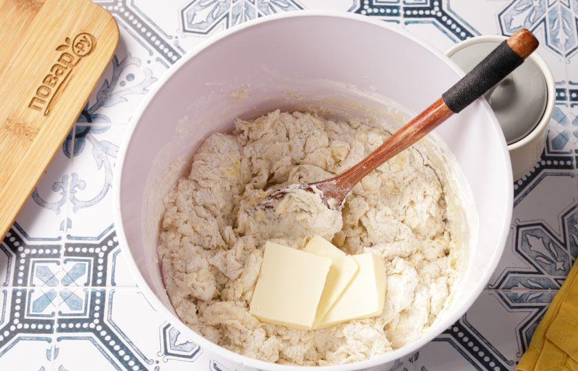 1. Этап. Калмыцкие борцоки: Перемешайте тесто ложкой и добавьте мягкое сливочное масло.