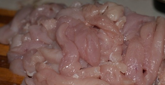 1. Этап. Курица по-пекински в кисло-сладком соусе: Промываем куриное филе под холодной водой и даем ему немного обсохнуть, затем нарезаем его на полоски шириной примерно 1,5 сантиметра.