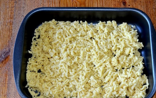 1. Этап. Торт Муравьиная горка: Духовку разогрейте до 180 градусов. Тесто натрите на крупной терке и выложите в форму.