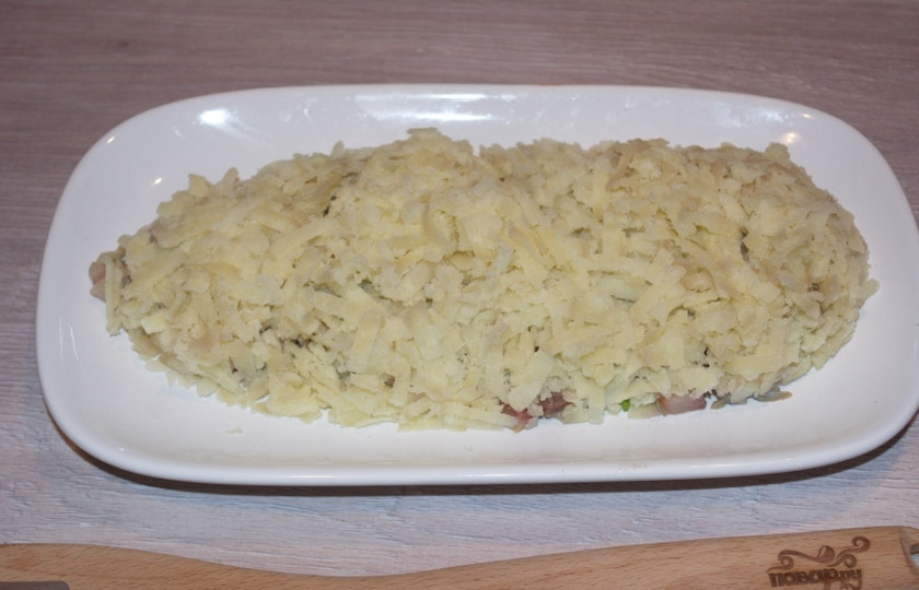 1. Этап. Салат Лисий хвост: Картофель, сваренный в мундире, очищаем и натираем на терке. Выкладываем поверх всего, слоем.