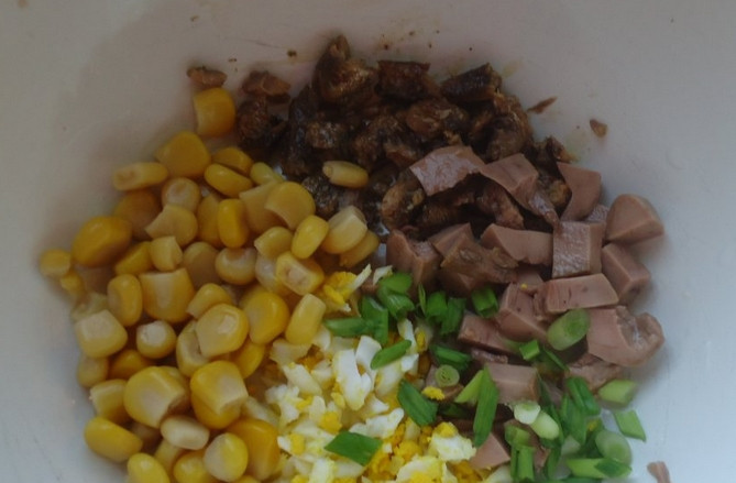 1. Этап. Салат из печени трески с кукурузой: Вареное яйцо натрите на терке, лук измельчите, а с кукурузы слейте жидкость. В салатницу выкладываем: печень трески, шпроты, яйцо, кукурузу и зелень.