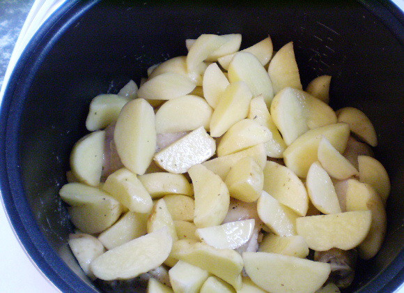 1. Этап. Тушеная картошка с курицей в мультиварке: 5. В кастрюлю мультиварки кладем сначала ножки, посыпаем специями и жарим пару минут. Сверху кладем картофель, перемешиваем и обжариваем. Жир будет вытапливаться из ножек.