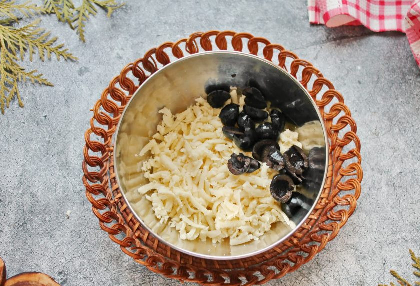 1. Этап. Куриные рулетики с грибами, маслинами и сыром: Сыр натрите на средней терке, маслины разрежьте на части и смешайте все в миске.
