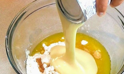 1. Этап. Простой рецепт кекса в микроволновке: Далее добавьте сгущенное молоко и хорошо все перемешайте.