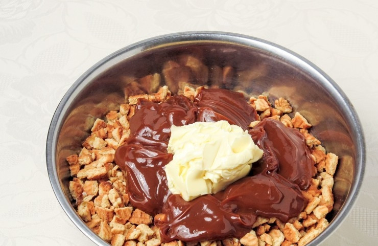 1. Этап. Торт из печенья и вареной сгущенки: Добавьте к печенью мягкое масло и варёную сгущёнку. Ингредиенты перемешайте.