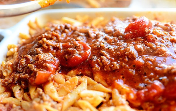 1. Этап. Запеканка с пастой, фаршем и сыром: Выкладываем макаронную смесь в форму для запекания. Сверху заливаем оставшимся соусом, при желании - присыпаем небольшим количеством тертого сыра.