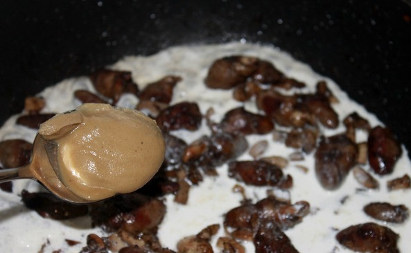 1. Этап. Куриные сердечки в сливках: Затем вливаем сливки и добавляем горчицу, солим и перчим все, перемешиваем и продолжаем тушить под крышкой до загустения соуса.