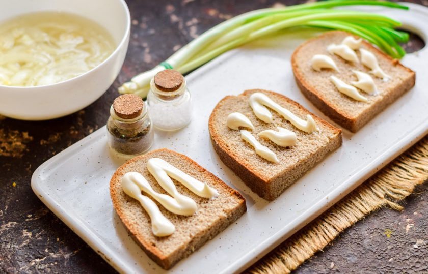 1. Этап. Бутерброды Сельдь под шубой: Хлеб нарежьте ломтиками и смажьте небольшим количеством майонеза.