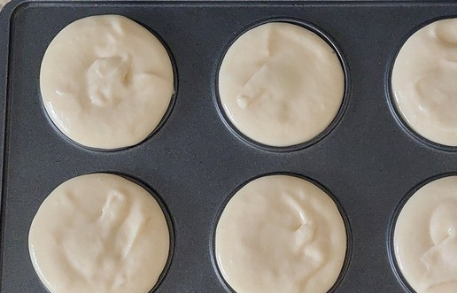 1. Этап. Творожные пончики в мультипекаре: В мультипекарь установить панели для пончиков. Включить и подождать пока загорится зелёный индикатор. Наливать в ячейки по 1 ч. л. с горкой теста. Бережно закрыть и защёлкнуть крышку.