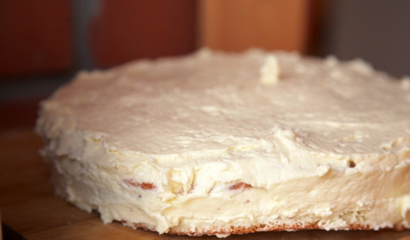 1. Этап. Бисквитный торт с орехами: Выпекать бисквит нужно 25 минут. Когда он будет готов, его нужно полностью остудить, а затем разрезать на 3 коржа. Приготовьте крем, взбив сливочное масло со сгущёнкой, и промажьте им коржи, выкладывая их один на другой. Бока торта тоже промажьте кремом.