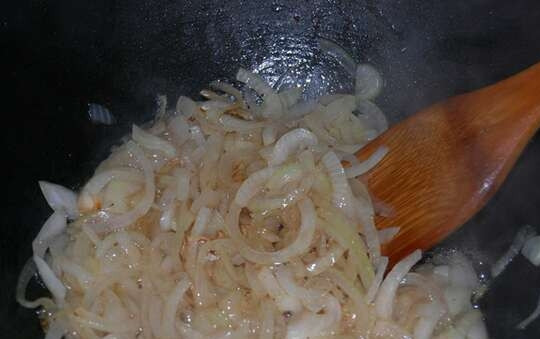 1. Этап. Мясо в пиве по-чешски: Вынимаем куски сала из казана. Лук режем полукольцами и обжариваем на полученном жире до прозрачного состояния.