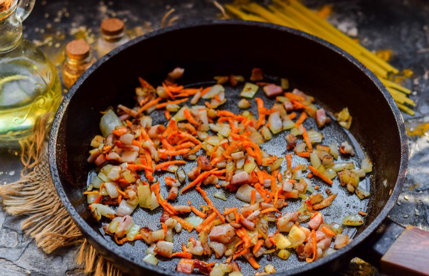 1. Этап. Суп с лапшой и капустой: Морковь, лук и бекон поджарьте на сковороде в течение нескольких минут. Выложите в кастрюлю.