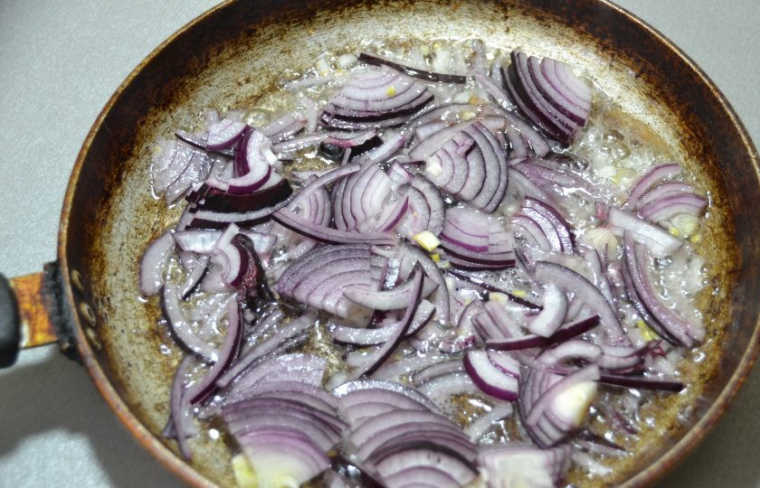 1. Этап. Пицца по-немецки: Обжарьте лук на сковороде на смеси растительного и сливочного масла.