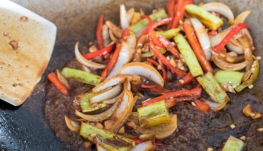 1. Этап. Курица с кешью по-тайски: 8. В разогретое масло выложите чеснок. Через минутку добавьте лук и остальные овощи. Обжарьте пару минут, помешивая.