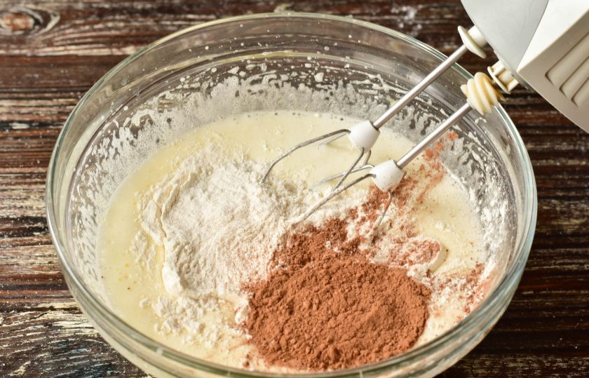 1. Этап. Шоколадный бисквит на молоке: Затем добавьте муку и какао. Перемешайте силиконовой лопаткой тесто.