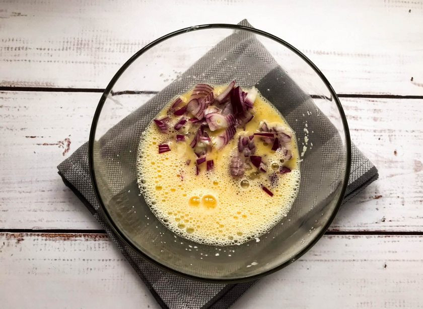 1. Этап. Горячие бутерброды с манкой: Лук очистите от шелухи, мелко нарежьте и выложите в яичную смесь.