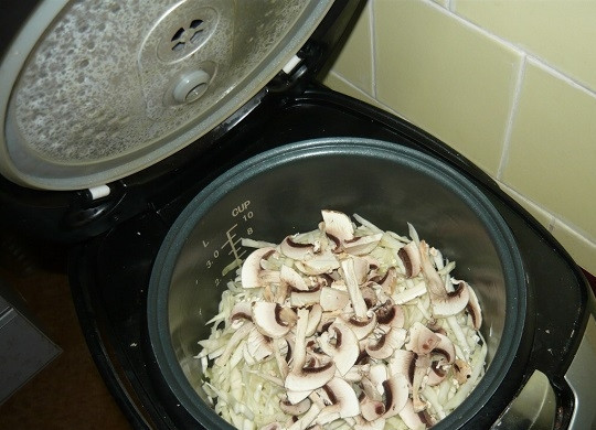 1. Этап. Капуста с грибами в мультиварке: 5. Минут через 7-10 можно добавить в чашу грибочки. Аккуратно перемешайте и продолжайте обжаривать.