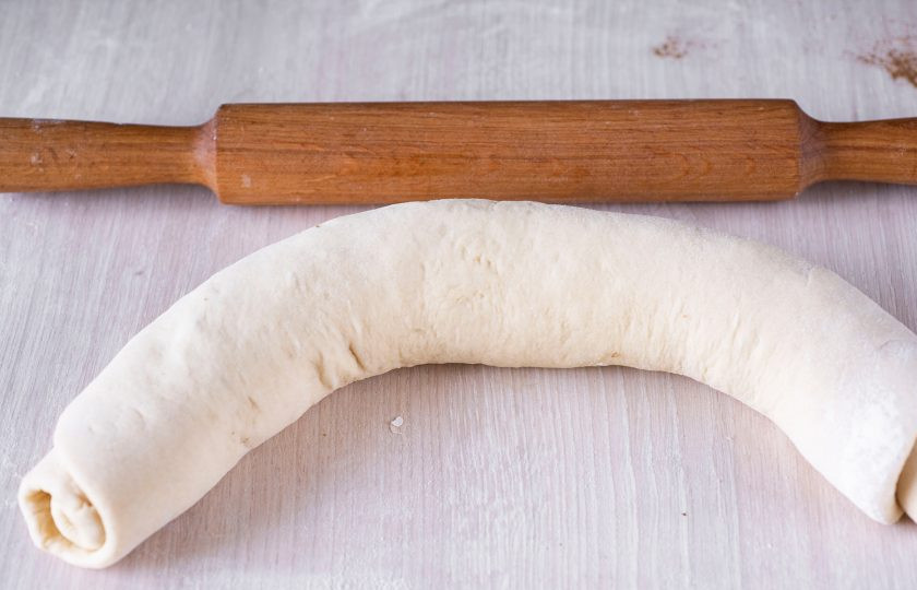 1. Этап. Булочки с грецкими орехами и корицей: Скрутите пласт теста с начинкой в рулет.
