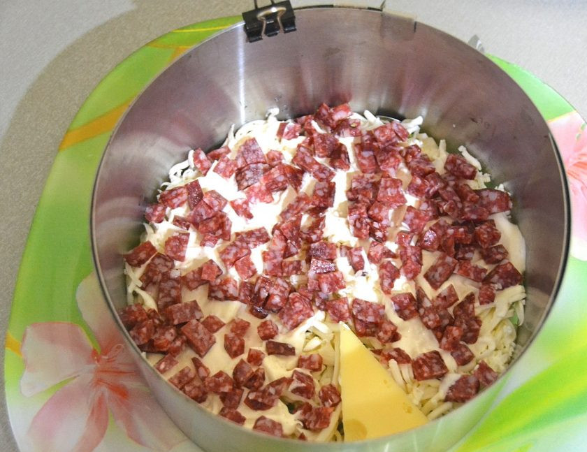 1. Этап. Салат Мышки-шалунишки: Следующим слоем выложите измельченную в мелкий кубик копченую колбасу.