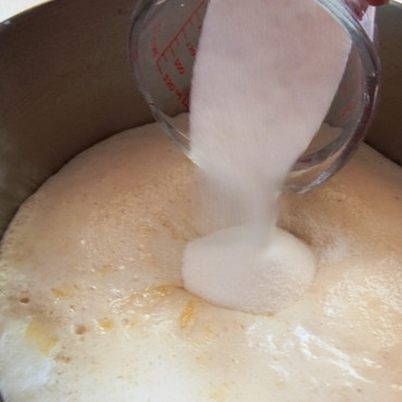 1. Этап. Вишневые бухты: Когда опара поднимется - добавляем в нее яйцо, растопленное сливочное масло, 3/4 стакана сахара и ванилин.