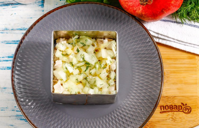 1. Этап. Салат Мужские слезы с гранатом: Нарежьте маринованный лук кубиками и выложите сверху на мясо. Лук можно нарезать заранее и замариновать в яблочном уксусе примерно на 10 минут.