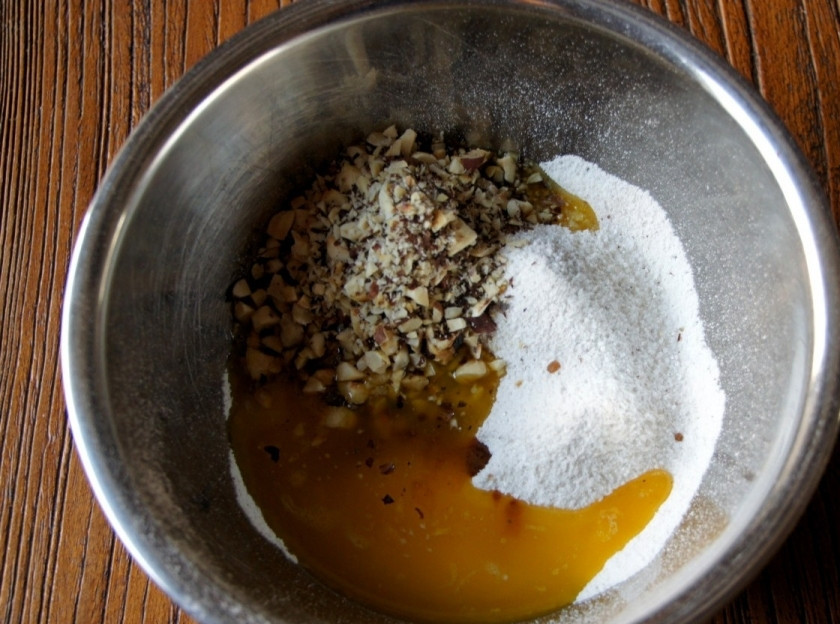 1. Этап. Ванильный чизкейк: Обжарьте лесные орехи. Измельчите их. Растопите сливочное масло. Смешайте в чашке муку, ванилин, 50-80 грамм сахара, растопленное сливочное масло и измельчённые орехи. Замесите тесто.