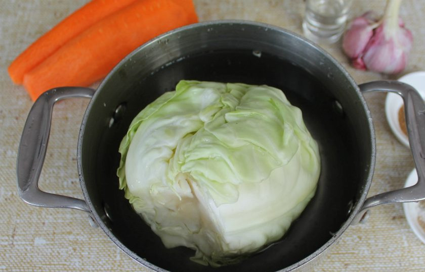 1. Этап. Капуста фаршированная морковью: Удаляем кочерыжку у капусты и кладем ее в кастрюлю с водой. На малом огне кипятим около 3 минут. Листья капусты станут мягче и будут легко сниматься.