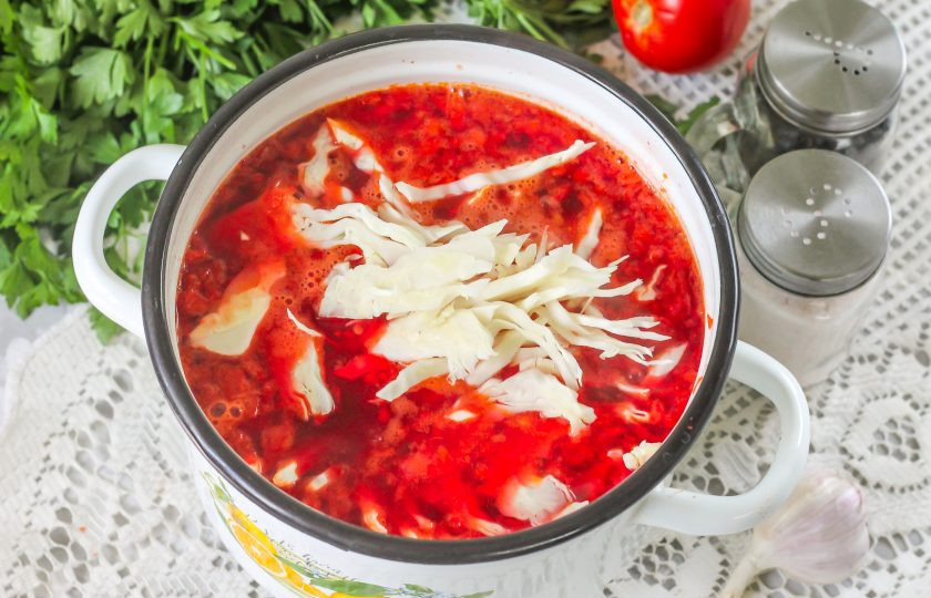 1. Этап. Борщ с болгарским перцем: Нарежьте свежую капусту и добавьте ее в кастрюлю практически сразу после добавления зажарки. Посолите и всыпьте сахар. Отварите в течение 3-5 минут до готовности блюда. Обязательно попробуйте его на вкус, при необходимости - досолите. По желанию можете влить 1 ст.л. 6% уксуса, если любите подкисленный вкус борща. Очистите чесночные зубчики и спрессуйте их в емкость после промывки.