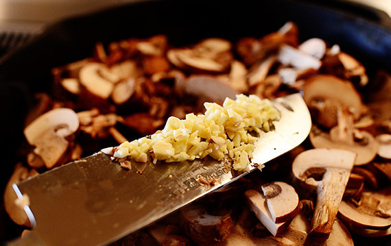 1. Этап. Слоеная пицца с грибами: Добавьте чеснок и специи, перемешайте.