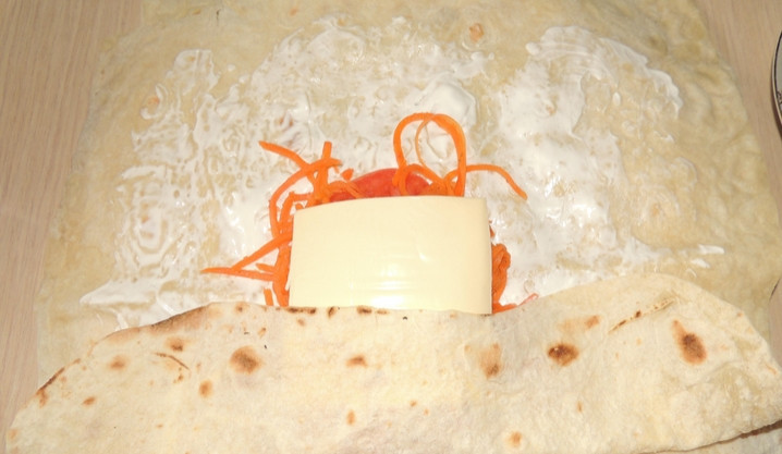 1. Этап. Лаваш с морковью и сыром: Аккуратно сворачиваем лаваш конвертиком.