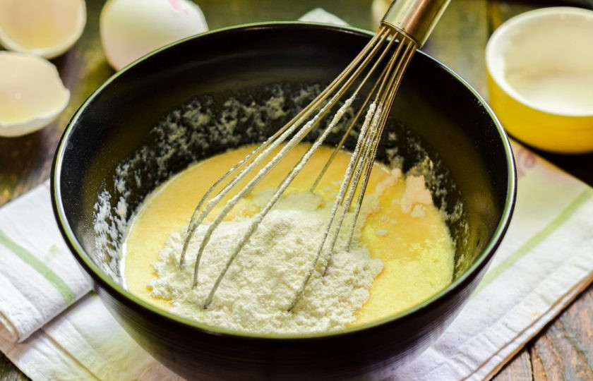 1. Этап. Оладьи на кефире без масла: Теперь добавляйте пшеничную муку и разрыхлитель, перемешивайте тесто венчиком или ложкой.