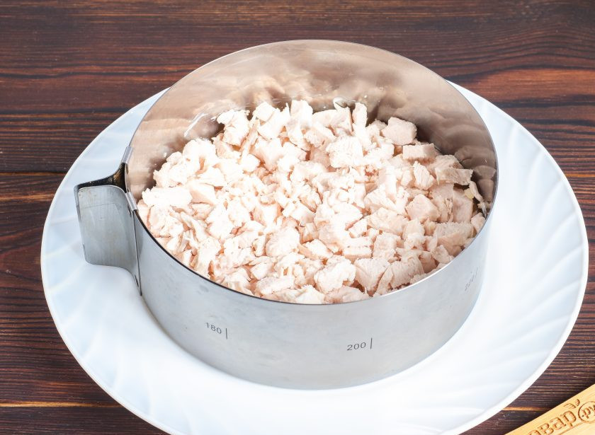 1. Этап. Салат Царский с курицей и шампиньонами: Второй слой – куриное филе нарезанное небольшими кубиками и майонез.