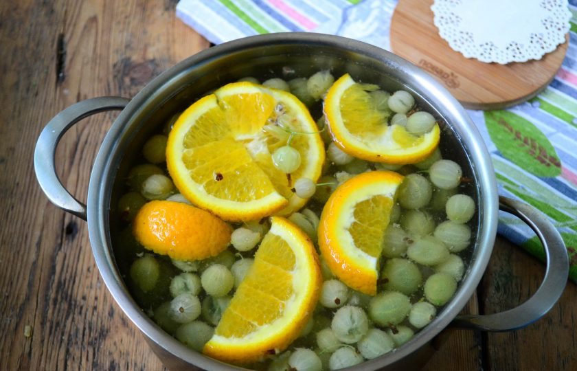 1. Этап. Компот из крыжовника с апельсином на зиму: Вскипятите воду, отправьте в нее сахар, крыжовник и порезанный апельсин. Проварите в течение 5 минут.