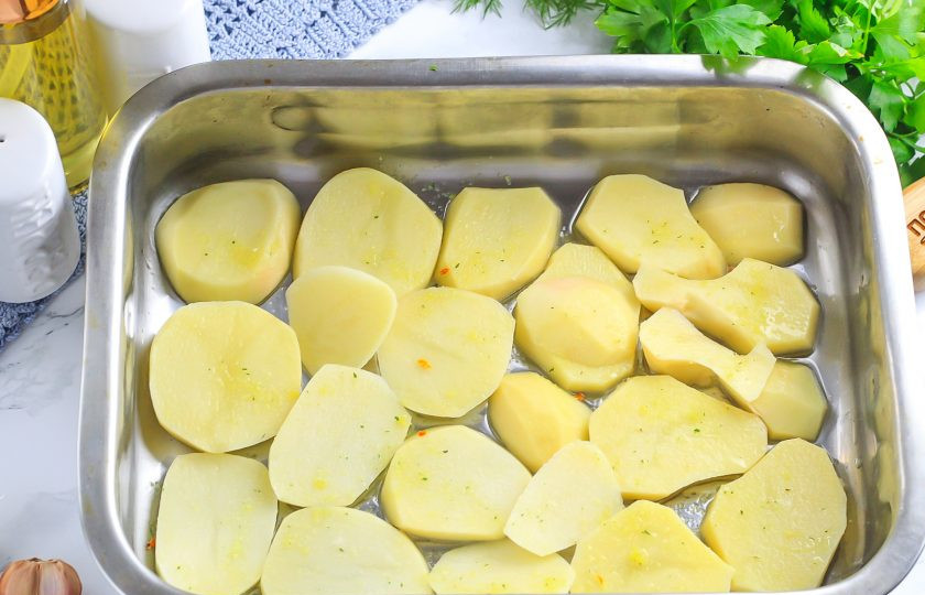 1. Этап. Золотистый карп с шалфеем: Картофель нарежьте ломтиками. Смажьте форму растительным маслом и выложите в нее ломтики картофеля. Присыпьте их приправой для рыбы.