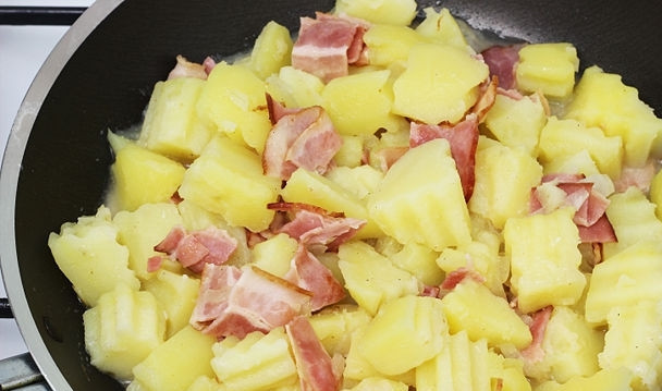 1. Этап. Салат из картофеля без майонеза: Картофель с беконом добавьте в сковороду к луку и хорошо перемешайте.