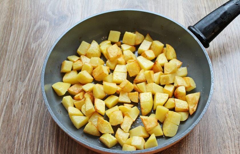 1. Этап. Жаркое по-киевски: Картофель почистите, сполосните и порежьте средним кубиком. В чистую сковороду налейте оставшееся масло и разогрейте его на среднем огне. Выложите картофель и обжарьте его до румяной корочки, примерно 10-15 минут. В конце немного посолите.