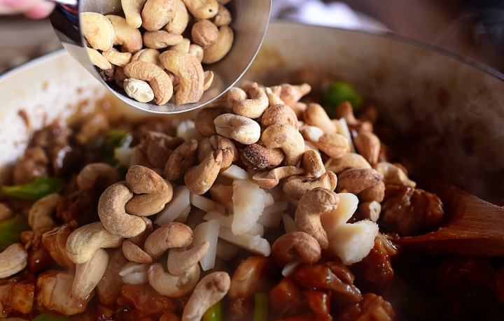 1. Этап. Куриная подлива с кешью: 4. Когда мясо птицы обжарится и немного проварится в бульоне, отправьте к нему орехи кешью и готовьте еще 10-15 минут.