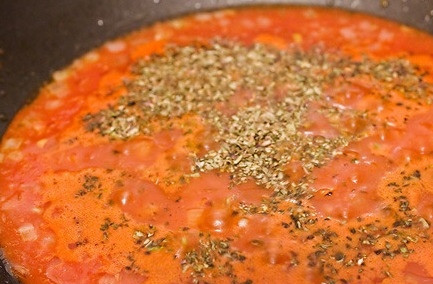 1. Этап. Курица по-милански: Выкладываем томатную массу на сковородку с обжаренным луком, вливаем вино, добавляем базилик, соль и перец. Перемешиваем и тушим на медленном огне 10 минут.