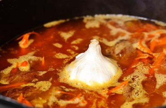 1. Этап. Простой рецепт плова из баранины: 8. Влейте горячую воду (она должна быть на палец выше мяса с овощами примерно). Добавьте немного соли и специй. В центр поставьте вымытую и обсушенную головку чеснока. На медленном огне оставьте томиться на 1 час.