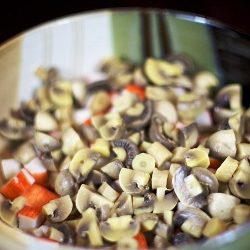 1. Этап. Салат Аншлаг: Грибы нарезаем на половинки или четвертинки (в зависимости от их крупности) и добавляем в салатницу (без жидкости, естественно).