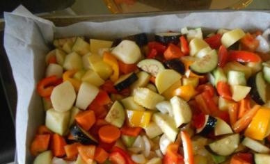 1. Этап. Гарнир к индейке в духовке: Выкладываем подготовленные овощи на противень, застеленный бумагой для выпечки. Поливаем растительным маслом, солим, перчим и посыпаем сухими травами. Перемешиваем.