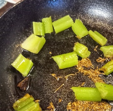 1. Этап. Баклажан, тушёный в остром соусе: Разогреть ещё 2 столовые ложки масла в сковороде, и готовить сельдерей 5 минут под крышкой, время от времени помешивая. Затем добавить семена зиры и тушить под крышкой ещё 5 минут