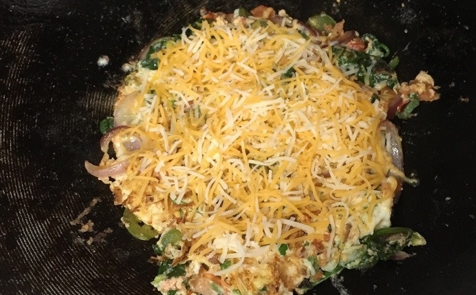 1. Этап. Домашний омлет с овощами: 6. Переверните омлет на другую сторону и посыпьте тертым сыром.