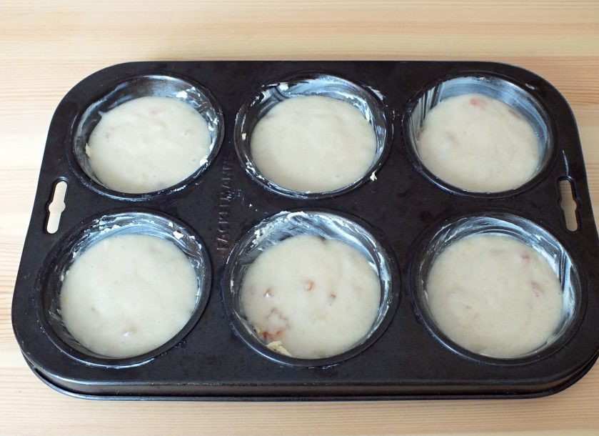 1. Этап. Кексики на Новый год Крысы: Формы для небольших кексов обильно смажьте сливочным маслом. Выложите тесто. Поставьте в разогретую духовку и выпекайте 12 минут.