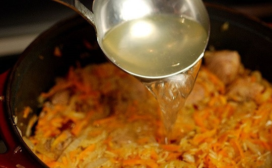 1. Этап. Плов узбекский: 11. Аккуратно влейте 4 стакана горячей воды или бульона, предварительно растворив в ней соль. Накройте крышкой, убавьте огонь до минимума. Томите до готовности.