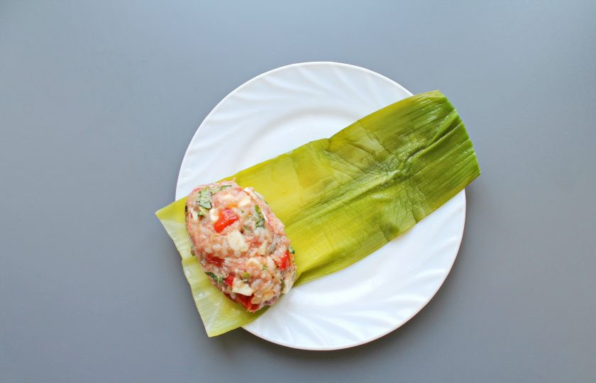 1. Этап. Голубцы в стеблях лука порея: Выложите листья порея внахлест и прижмите. Сформируйте из фарша котлету и выложите на один край, сверните в рулет.