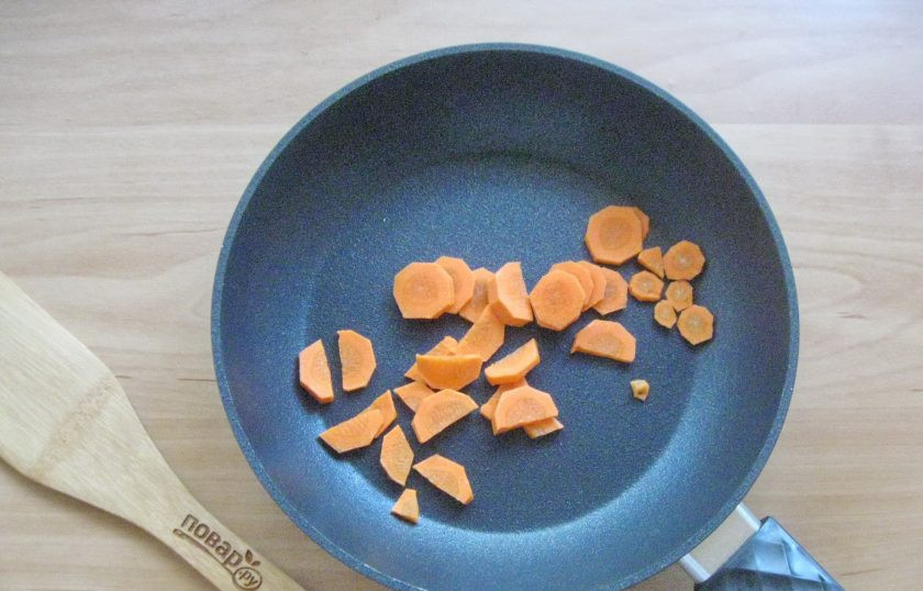 1. Этап. Фунчоза с красной рыбой: Морковь очистите, помойте и нарежьте произвольно. Выложите в сковороду.